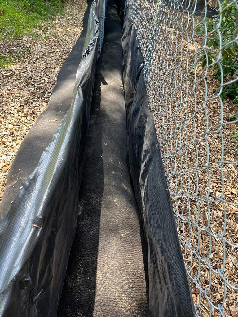 Chain-link tree preservation fence with trenchless sediment and erosion control over wood chips