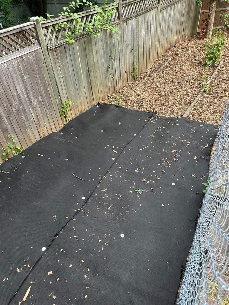 Root protection mat installed over 12 inches of wood chips inside a tree protection fence